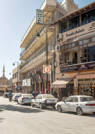 MADABA, JORDAN-FEBRUARY 2015. Street with cars circulating and people walking on a sunny day in Madaba, Jordan.のeditorial素材