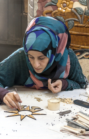 MOUNT NEBO, JORDAN-FEBRUARY 2015. Arab women with veil working in a pottery workshop.のeditorial素材