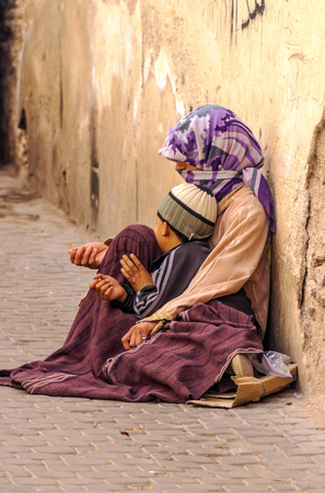 MARRAKESH, MOROCCO - JULY 2015 Streets of Marrakesh with a woman and her daughter begging.のeditorial素材