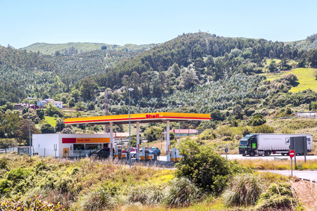 DEVA, BASQUE COUNTRY, SPAIN-JULY 2015. Truck refueling at a gas station surrounded by forest trees.のeditorial素材