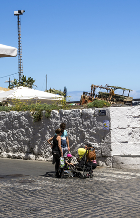 PUERTO DE LA CRUZ, CANARY ISLAND,  SPAIN - JUNE 2016. Anonymous tourists walking through a palm tree promenade in Puerto de la Cruz on a sunny day. ItÂ´s a touristic village near the sea.のeditorial素材