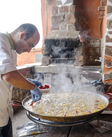 LA OROTAVA, CANARY ISLAND, SPAIN - JUNE 2018. Chef preparing a paella in a restaurant.のeditorial素材
