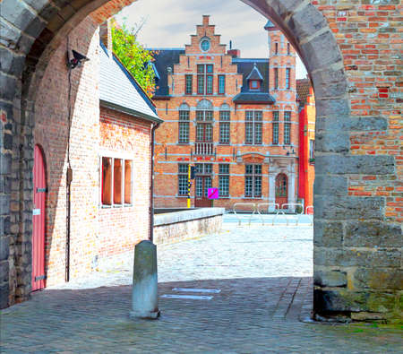 Streets of Bruges in Belgium with its medieval style facades on a cloudy day.の写真素材