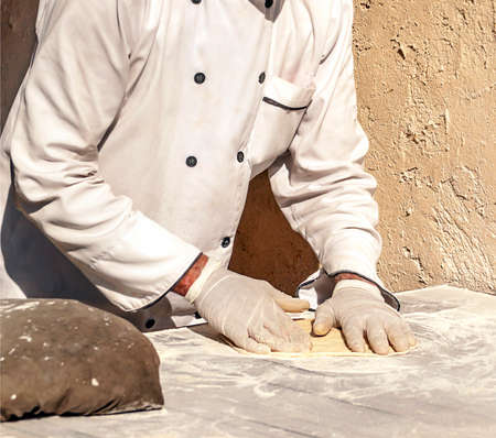 rab man making the dough from a pizza outdoors.