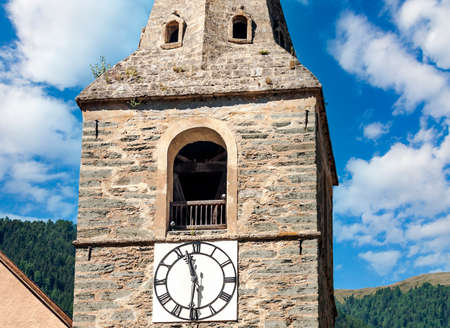 Ancient tower with clock of a church in Grimentz, switzerland on a sunny day.の写真素材