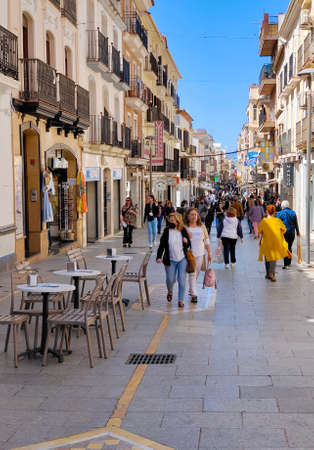 RONDA SPAIN - MAY 2022. Tourist walking in the shop street of Ronda in a sunny day.の写真素材