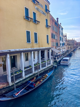 Venice, Italy - April 2023. Venice canals with boats sailing and tourists walking through its streets on a sunny dayのeditorial素材