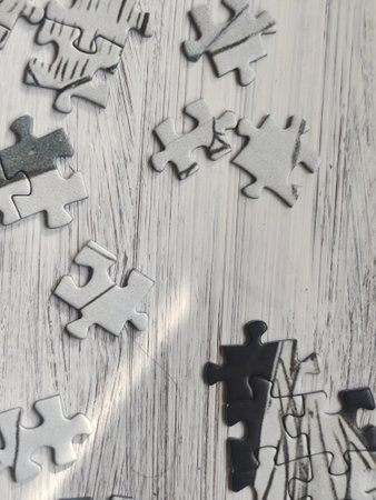 Jigsaw puzzle pieces on white wooden background. Top view. Copy space.の写真素材