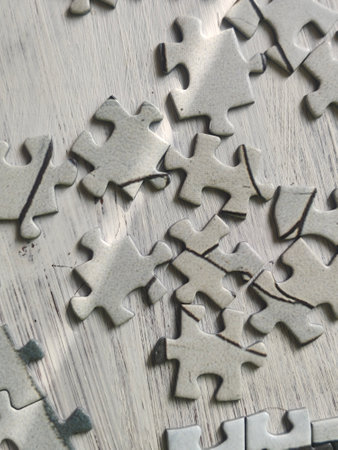 jigsaw puzzle pieces on a wooden surface, closeup of photoの写真素材