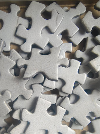 Jigsaw puzzle pieces on white wooden background. Copy space for text.の写真素材