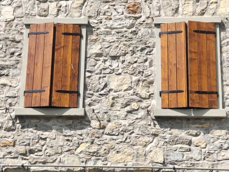 Wooden window shutters on a stone wall in a sunny dayの写真素材