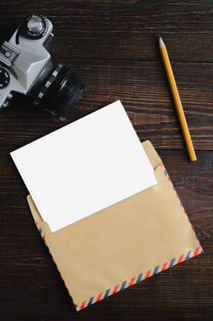 Mockup letter on the wooden table with camera and pencil.の写真素材
