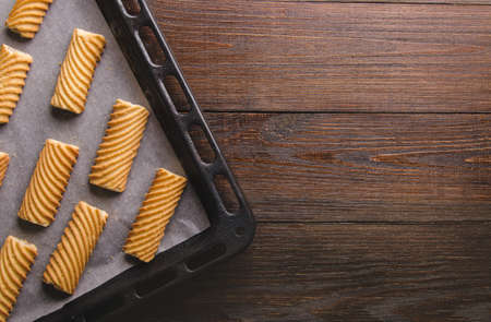 Homemade cookies on baking paper and rustic wooden table. Baking in oven.の写真素材
