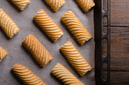 Gingerbread cookies on baking paper and rustic wooden table. Baking in oven.の写真素材