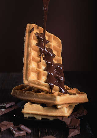 Belgian waffles with chocolate on a wooden tableの写真素材