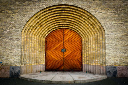 Wooden door on brick wall church in Copenhagenの写真素材
