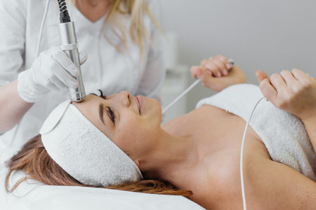 Electroporation without injection mesotherapy. Woman cosmetologist performs cosmetic procedureの写真素材