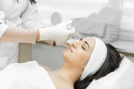 The path to perfection, where the botulinum therapy procedure helps a woman get rid of wrinkles and get the perfect face. Facial skin care in the beauty clinic. The work of a cosmetologistの写真素材