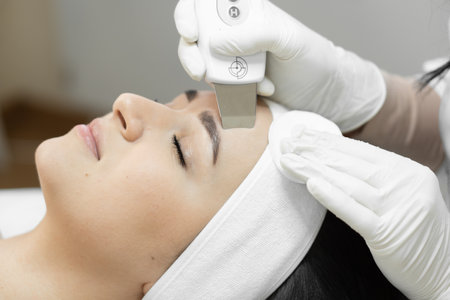 Feeling of freshness and rejuvenation: ultrasonic facial cleansing from a professional cosmetologist to care for skin health. Relaxation and relaxation in beauty salon. Woman enjoying procedure in spaの写真素材