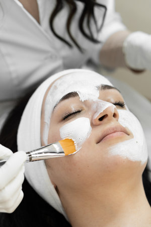 Mask for relaxation: how the procedure of applying a cosmetic mask on a womans face can create relaxation and a feeling of calm and relaxation during skin care in a spa beauty clinicの写真素材