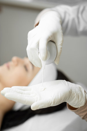 Cosmetic care: a woman receives individual facial skin care from a cosmetologist, which rejuvenates,...