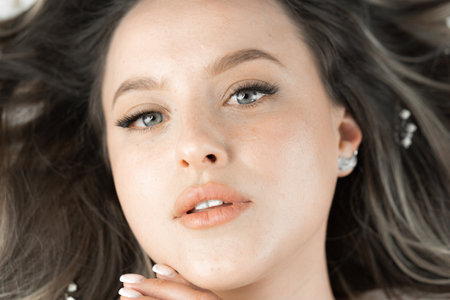 A beautiful woman model conveys expressiveness and purity womans face. Every detail is embodied in makeup, which emphasizes its natural beauty, radiance and healthy skin. Eyes, nose and lips close-upの写真素材