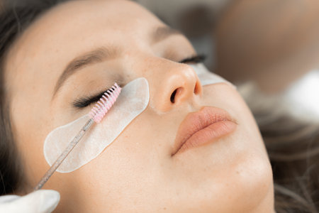 Look at fascinating photo that conveys ability cosmetologist to realize clients desirability to have naturally attractive eyelashes. Every movement beauticians hand is made with precision and skill.の写真素材
