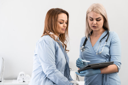 Medical examination: The doctor on the tablet shows the patient the results of the examination and tests, giving an insight into her state of health. Healthy dialogue: The doctor and the femaleの写真素材