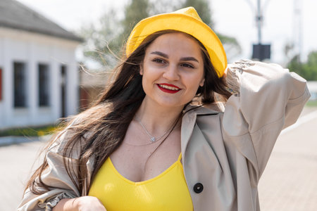 Bright expectations: a woman in yellow clothes with a suitcase conveys her impatient desire to open new horizons. Meeting with adventure: the image of a traveler with a suitcase in yellow clothes evokes a feeling of joy before starting the trip.の写真素材