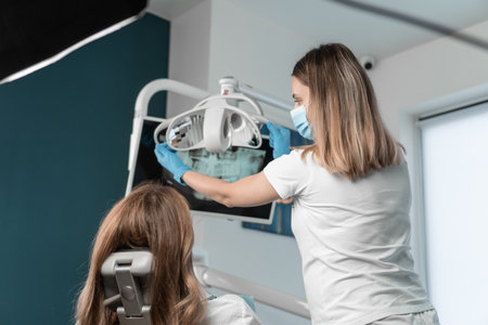 The dentist conducts a thorough examination and diagnosis of the patient to draw up an individual treatment plan. A dentist provides treatment and diagnostics using modern medical technologies.の写真素材