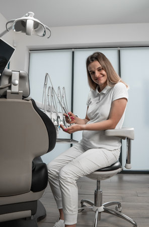 A dentist in a modern medical center looks at the camera and prepares for a treatment session. Implant placement is a reliable method of restoring lost teeth.の写真素材