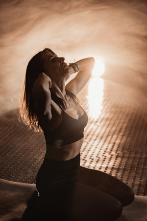 This sensual fitness portrait features atmospheric lighting that highlights the models beauty and focus, showcasing elegance and determination, evoking deep emotion and invigorating energyの写真素材