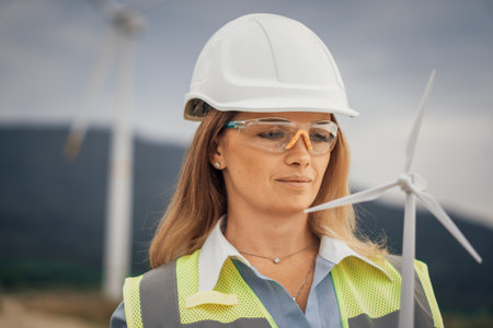 A skilled Female Engineer is currently conducting a detailed analysis of Wind Turbine Efficiency within a significant Renewable Energy Project aimed at promoting sustainable energy solutionsの写真素材