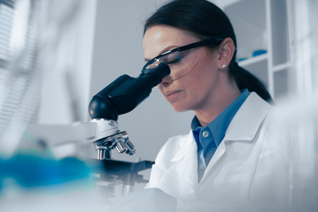 In a modern lab, a dedicated scientist observes biological specimens through a highpowered microscope, showcasing the precision and innovation vital for advancing science and researchの写真素材
