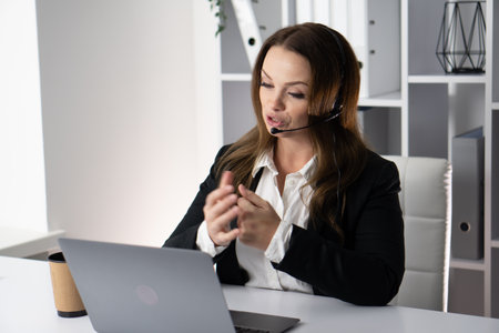 A dedicated and professional woman who is deeply engaged in virtual communication via various platforms to enhance her career and effectively collaborate with colleagues and clients remotelyの写真素材