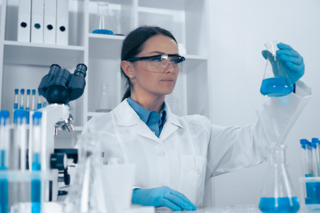 A skilled female scientist is analyzing chemical solutions in a modern lab, demonstrating her professionalism and innovative research, contributing significantly to the field of scienceの写真素材