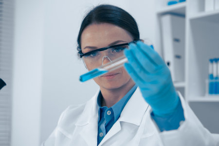 A skilled female scientist is conducting a meticulous analysis of liquid samples in a hightech lab using advanced tools. Her work is vital for advancements in biochemistry, chemistry, and healthcareの写真素材