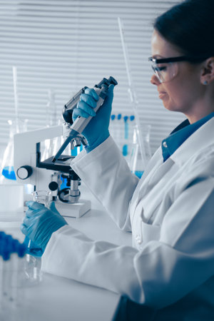 A dedicated scientist is in the laboratory, meticulously conducting detailed research using a highpowered microscope to explore various scientific phenomena and push the boundaries of knowledgeの写真素材