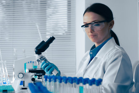 In a cuttingedge lab, a dedicated female scientist analyzes samples under a microscope, making significant contributions to the evolving field of scientific research across various disciplinesの写真素材