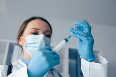 A healthcare professional prepares a vaccine in a sterile setting, following strict safety practices to ensure effective immunization and optimal patient care for everyones wellbeingの写真素材
