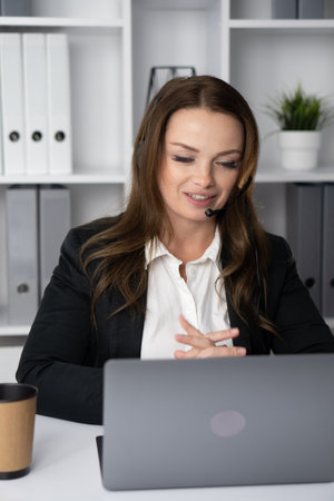 A dedicated business professional is engaged in a virtual meeting while efficiently working from the comfort of their own home, showcasing the importance of remote collaboration and engagementの写真素材