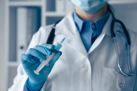 A healthcare professional diligently preparing a vaccine for administration in a clinic setting, showcasing the importance of careful procedures and adhering to safety protocols ahead of treatmentの写真素材