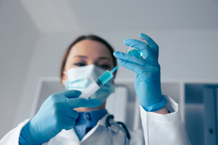 A skilled healthcare professional is diligently preparing a vaccine inside a modern clinic. The atmosphere is filled with an emphasis on hygiene and patient wellness as they take meticulous careの写真素材