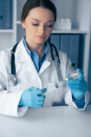A Healthcare Professional Engaged in the Preparation of a Vaccine for Administration, Ensuring Proper Techniques and Sterility Standards are Met Throughout the Procedure for Safe Immunizationの写真素材