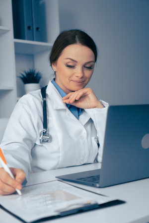 Thoughtful Medical Professional Engaged at Work, Demonstrating Dedication to Patient Care, Utilizing Technology for Analysis and Treatment Decisions in a Professional Healthcare Environmentの写真素材