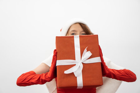 A joyful character in colorful festive attire holds a beautifully wrapped gift, embodying the spirit of celebration and holiday cheer, perfect for seasonal promotions and gatheringsの写真素材