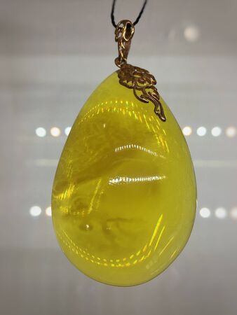 pendant of white royal amber from the Baltic Sea on a black background close-upの写真素材