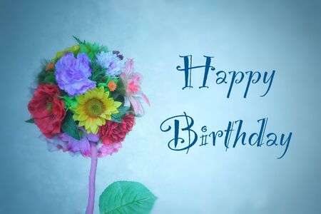 A bouquet of flowers and a birthday inscription on a blue background.の写真素材