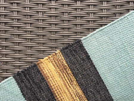 Gray wicker texture and woven multi-colored carpet.