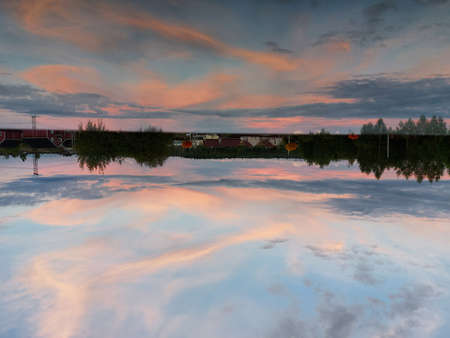A magnificent pink sunset is reflected in the surface of the lake